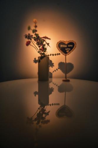 a table with a vase with flowers and a heart at AMADA CITY CENTER in Iaşi