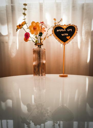 a vase with flowers and a heart on a table at AMADA CITY CENTER in Iaşi