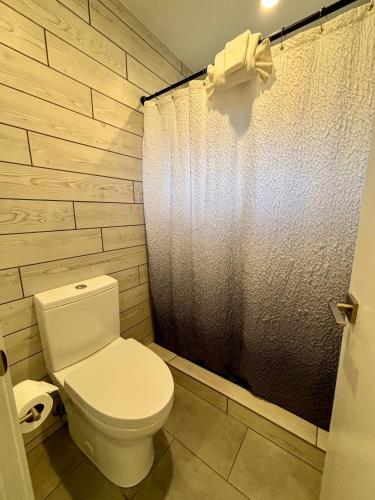 a bathroom with a toilet and a shower curtain at Hidden Valley Inn in Carmel Valley