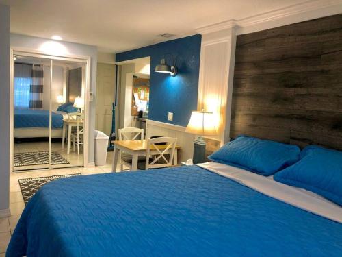 a bedroom with a blue bed and a bathroom at Sand Dollar Studio Pool Daily Rentals in Sarasota