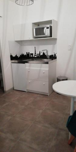 une cuisine avec un comptoir avec un micro-ondes dans l'établissement florensac, à Florensac