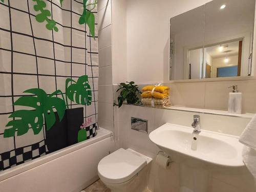 a bathroom with a sink and a toilet and a mirror at Issara Apartments 49 - Great location & Private Parking in Portsmouth