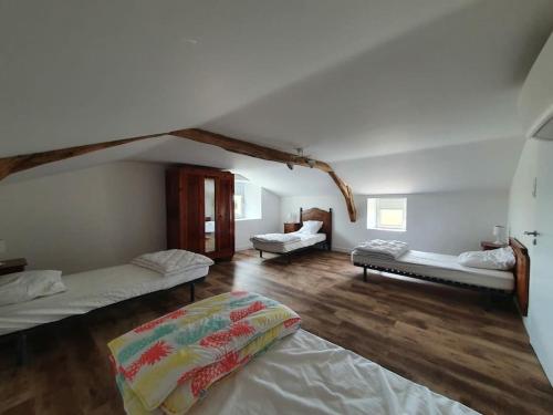 ein Zimmer mit drei Betten in einem Zimmer in der Unterkunft Gîte de campagne 14 personnes in Bégrolles-en-Mauges