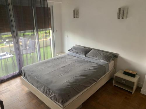 un lit dans une chambre avec une grande fenêtre dans l'établissement Vence T3 vue mer grande terrasse, à Vence