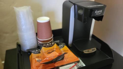 a table with a coffee maker and paper towels at El Camino Inn in Daly City