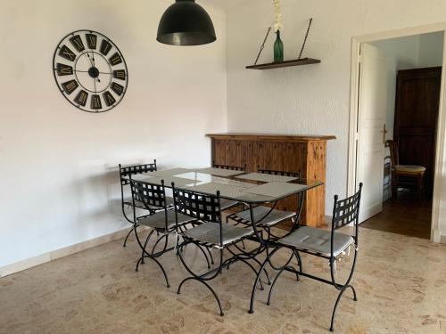 une table à manger avec des chaises et une horloge murale dans l'établissement Vence T3 vue mer grande terrasse, à Vence