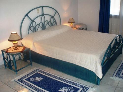 a bedroom with a large bed and two tables with lamps at Residence Gerani in Agios Nikolaos