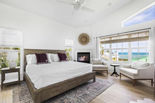 a white bedroom with a bed and a fireplace at Island Cottage Inn in Flagler Beach