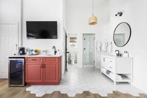 a white bathroom with red cabinets and a sink at Island Cottage Inn in Flagler Beach