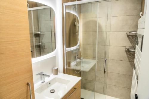 une salle de bain avec un lavabo et une douche avec un miroir dans l'établissement Résidence Les Cembros - Studio pour 4 personnes au coeur de station MAE-8941, aux Orres