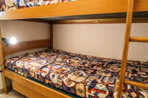 - un lit superposé avec une couette dans une chambre dans l'établissement Résidence Les Cembros - Studio pour 4 personnes au coeur de station MAE-8941, aux Orres