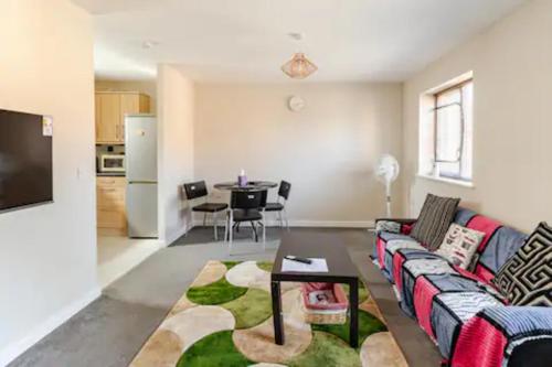 a living room with a couch and a table at Lovely Apartment with Garden & Parking in Milton Keynes