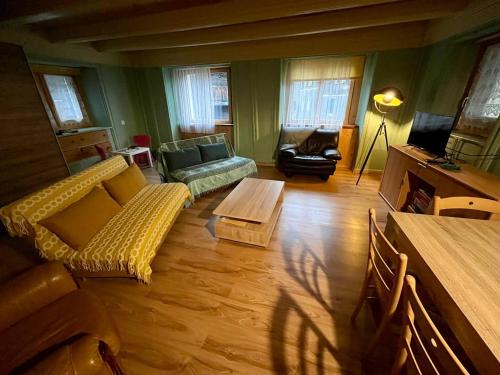 a living room with a couch and a table at Historische Maisonettewohnung bis 10 Gäste, Magic Pass Belalp, Rosswald und mehr in Naters