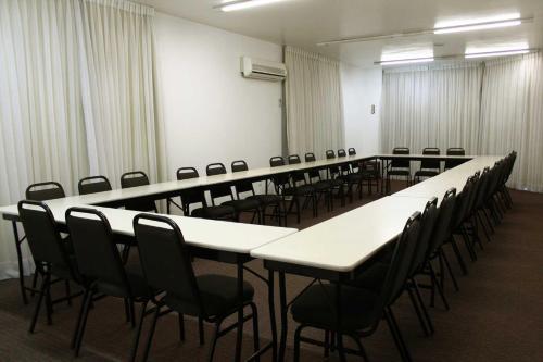 a conference room with tables and chairs in it at Hotel Germânia in Joinville