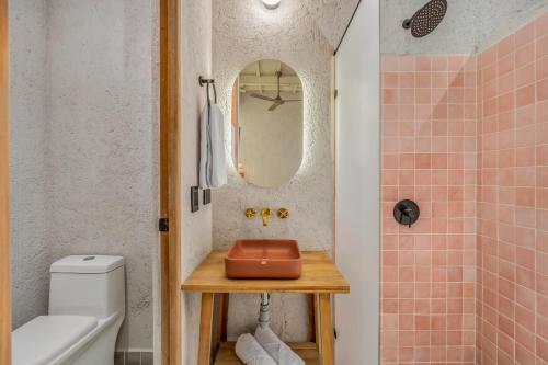 a bathroom with a sink and a toilet and a mirror at Botánica Casa Hotel Manila by HOUSY HOST in Medellín
