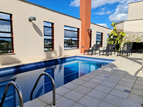 a swimming pool in a house with windows at Hotel Germânia in Joinville