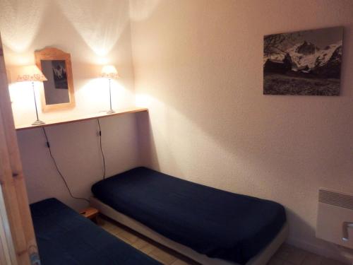 Cette petite chambre comprend un lit et une lampe. dans l'établissement Résidence Les Arolles - 2 pièces cabine 6 personnes exposé Sud-Est MAE-3731, à Valloire