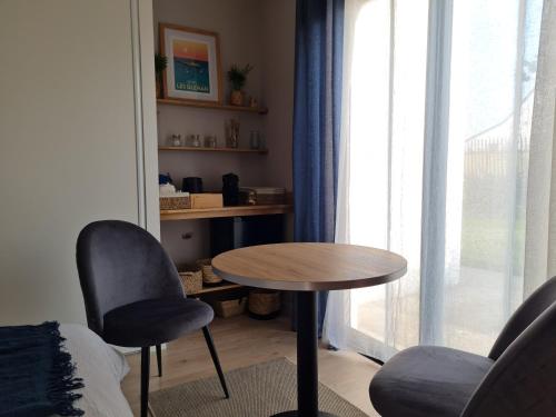 Habitación con mesa, 2 sillas y ventana en Escale à Kergrenn, en Fouesnant