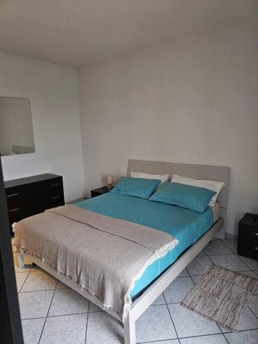 a bedroom with a large bed with blue pillows at Ca' del Sole in Calliano