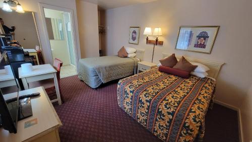 a hotel room with a bed and a desk at El Camino Inn in Daly City