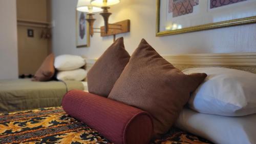 a bunch of pillows sitting on a couch in a living room at El Camino Inn in Daly City