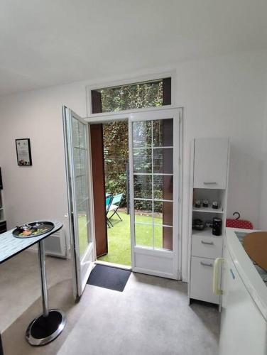 une cuisine avec une porte ouverte sur une cour dans l'établissement Appartement La Pause Bleue, à Lourdes