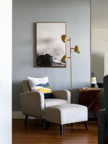 a living room with a chair and a lamp at Remodeled 3 Bedroom Oceanfront Condo — Sleeps 8 in Wailuku