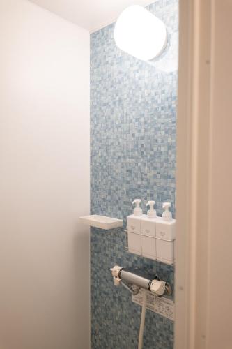 a bathroom with a blue tiled wall with a light at RIVER CENTRAL HIROSHIMA - Vacation STAY 59342v in Hiroshima