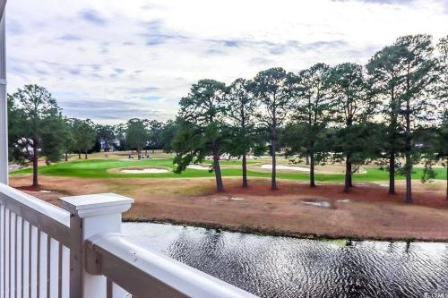 a view of a golf course from the balcony of a house at Beautiful 1500 s f 3 Bd - 2 Ba condo overlooking stream and golf course in Myrtle Beach
