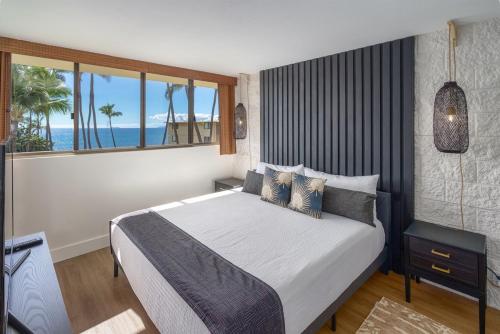a bedroom with a bed with a view of the ocean at Chic Condo— Renovated & Refurnished 2023 / 2024 in Wailuku