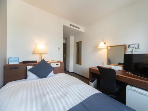 a hotel room with a bed and a desk and a television at Sun Hotel Kokubu - Vacation STAY 62412v in Kirishima