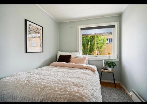 a bedroom with a bed and a window at Aurora Stay- Aurora garden Apartment in Tromsø