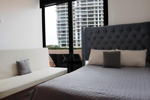 坎昆Luxury Apt with Balcony, Marina Puerto Cancún的一间卧室，里面有一张床和一扇大窗户。