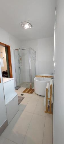a white bathroom with a tub and a shower at Studio Apartment in Collingwood Park