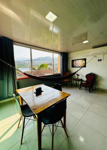 a room with a table and chairs and a large window at Havana Dance School & Hostel in Cali