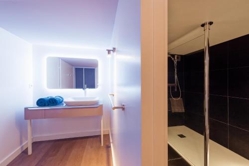a bathroom with a sink and a shower at La Villa Bleue, Luxe, Piscine et Spa in Capdenac