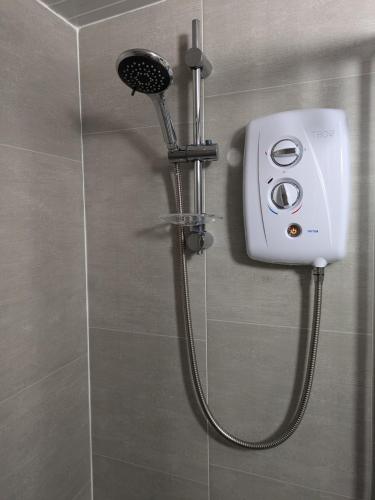 a shower with a shower head in a bathroom at Moira Garden Tiny Home in Moira