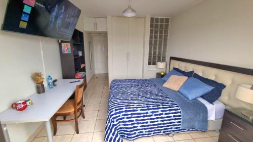 a bedroom with a bed and a desk and a television at Habitación con Baño privado en Departamento Compartido in Lima