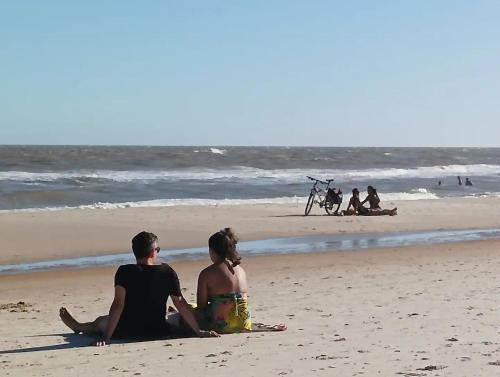 a man and a woman sitting on the beach at Entre naturaleza a 1 cuadra de la playa/Jacuzzi in Salinas 