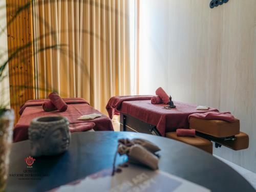 a room with two beds and a table at Barrilario Douro Wine Hotel e Spa - Quinta São Jose do Barrilario in Armamar