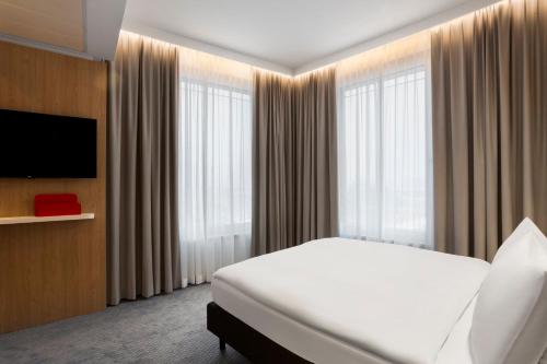 a hotel room with a bed and a flat screen tv at Holiday Inn Express Munich City West by IHG in Munich