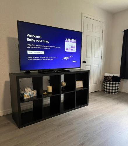 a flat screen tv on top of a black entertainment center at The Sanford Foodie Guest House in Sanford