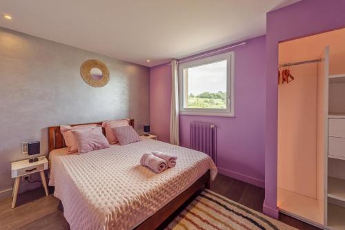 a bedroom with a bed with purple walls and a window at La Villa Bleue, Luxe, Piscine et Spa in Capdenac