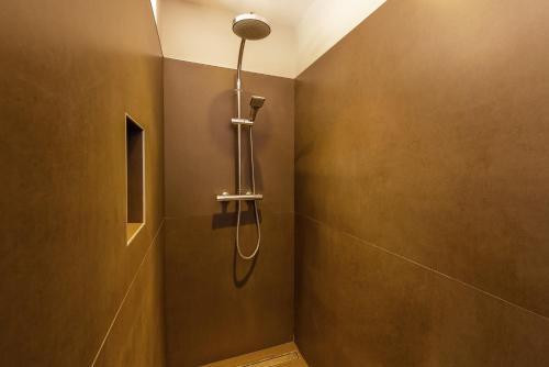 a bathroom with a shower with a shower head at La Villa Bleue, Luxe, Piscine et Spa in Capdenac