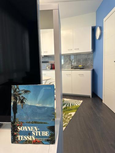 a book sitting on a table next to a kitchen at LuganoApartment in Lugano