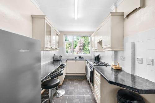 a kitchen with white cabinets and black counter tops at HILLTOP PLACE SUITES 5 beds for CONTRACTORS and FAMILIES near MEADOWHALL with FREE PRIVATE PARKING in Sheffield