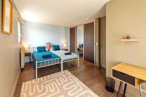 a bedroom with a blue bed with a teddy bear on it at La Villa Bleue, Luxe, Piscine et Spa in Capdenac