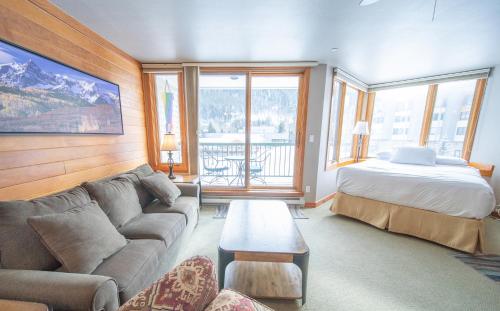 a living room with a couch and a bed at Lakeside 1476 by SummitCove Lodging in Keystone