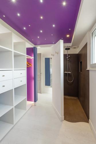 a bathroom with a purple ceiling and white cabinets at La Villa Bleue, Luxe, Piscine et Spa in Capdenac