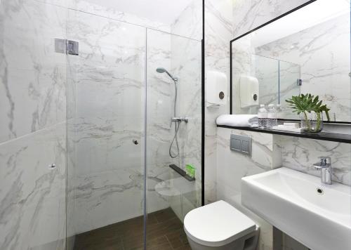 a bathroom with a shower and a toilet and a sink at Hotel Boss in Singapore
